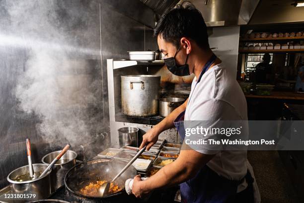 Co-founder and chef Andrew Chiou photographed cooking in the kitchen of his takeout only restaurant, Lucky Danger, in Washington, DC.