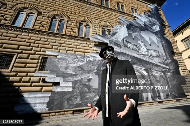 French artist JR poses during the unveiling of his visual installation "La Ferita" on the facade of the Renaissance Palazzo Strozzi in Florence on...