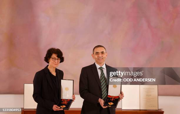 Ozlem Tureci and her husband Ugur Sahin, both scientists and founders of BioNTech, pose with their orders after they were awarded the Federal Cross...