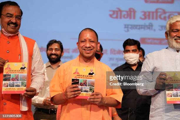 Yogi Adityanath, chief minister of Uttar Pradesh, center, holds a book during a news conference in Lucknow, India, on Friday, March 19, 2021. The...