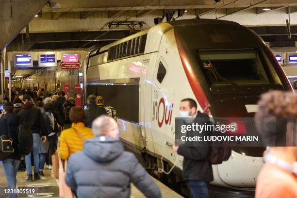 Parisians walk along a platform to catch a TGV Qui train leaving from the Gare Montparnasse serving the west and southwest of France, in Paris on...