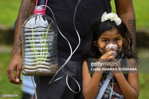 Young climate activist wears a mask as she with others take part in a demonstration titled 'ecocide' or rapid deforestation and destruction of...