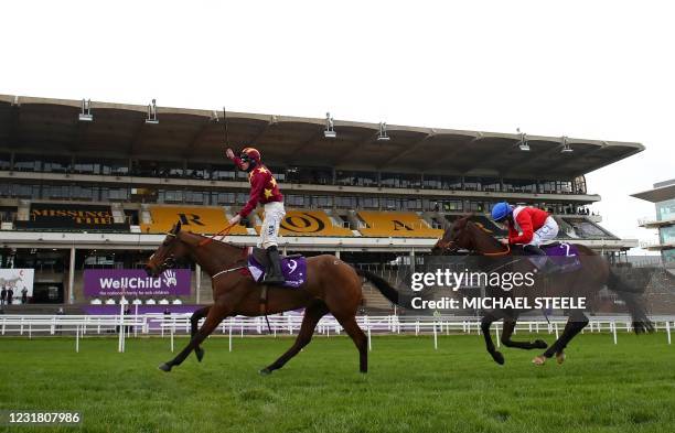 Jockey Jack Kennedy on Minella Indo rides past empty stands ahead of second-placed jockey Rachael Blackmore on A Plus Tard to win the Gold Cup trophy...