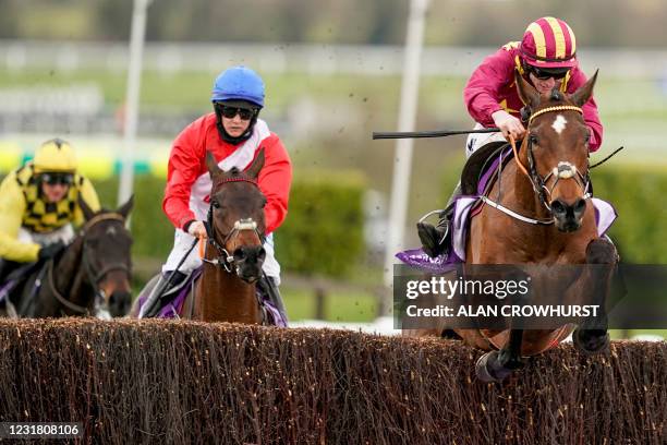 Jockey Jack Kennedy rides on Minella Indo to take first place ahead of second-placed jockey Rachael Blackmore on A Plus Tard and third-placed jockey...