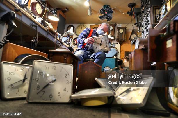 Clock repairman Ross A. Hochstrasser works on one of a dozen Weymouth High School classroom clocks circa early 1970's in his repair shop, the Ross A....