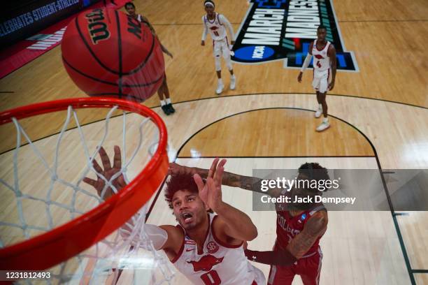 Justin Smith of the Arkansas Razorbacks and Jordan Burns of the Colgate Raiders go up for a rebound in the first round of the 2021 NCAA Division I...