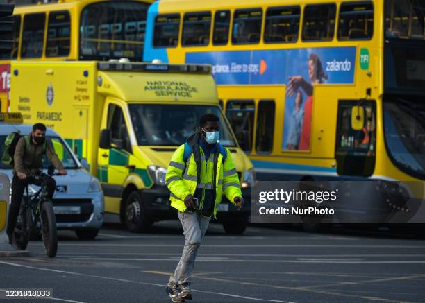 Man wearing a face mask crosses the street in Dublin city center during Level 5 Covid-19 lockdown. On Friday, 19 March 2021, in Dublin, Ireland.