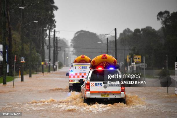 State Emergency Service vehicles approach flooded residential areas in western Sydney on March 20 amid mass evacuations being ordered in low-lying...