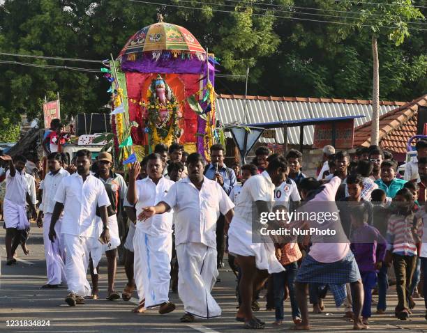 Hindu devotees escort a large clay idol of Lord Ganesh along the road while dancing and singing during the Ganesh Chaturthi festival in Velankanni,...