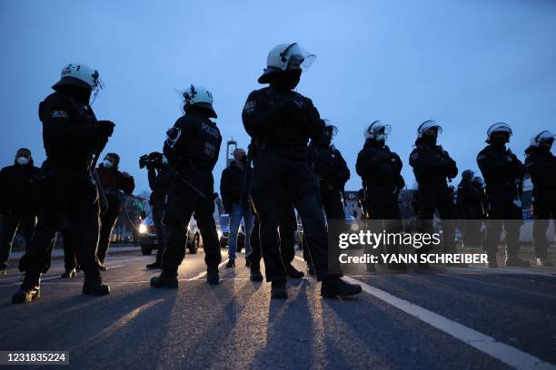 Police in riot gear and wearing face masks are pictured at the end of a demonstration demanding the compliance of basic rights and an end of the...