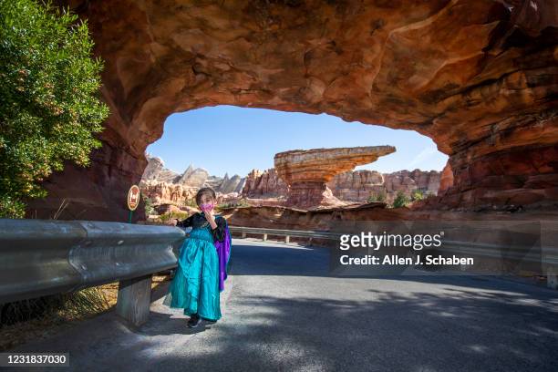 March 18: Ally Carrasco dressed in a Anna from Frozen movie costume, poses for a photo at the scenic entrance to Cars Land during the debut of Disney...