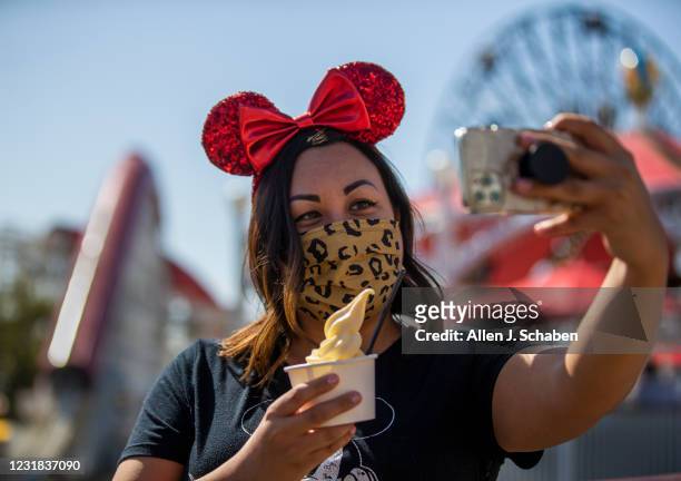 March 18: Monica Link, of Sacramento, takes a photo with a Dole Whip at the Adorable Snowman Frosted Treats on Pixar Pier during the debut of Disney...