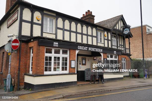 Landlady Emma Parkhouse and Landlord Sheridan Edwards pose for a photograph outside the Great Northern pub in St Albans, north of London on March 18,...