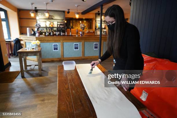 Landlady Emma Parkhouse poses for a photograph inside the Great Northern pub in St Albans, north of London on March 18, 2021. - Pots of paint rather...