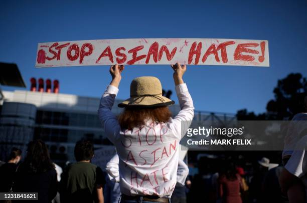 Sally Sha holds up a sign during a Stop Asian Hate rally at Discovery Green in downtown Houston, Texas on March 20, 2021.