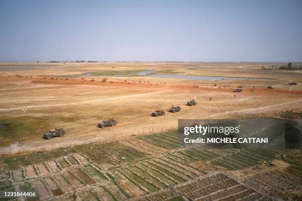 An aerial photo shows Malian Army vehicles patrolling near the town of Konna on March 20, 2021 as the Malian Prime Minister and his delegation visit...