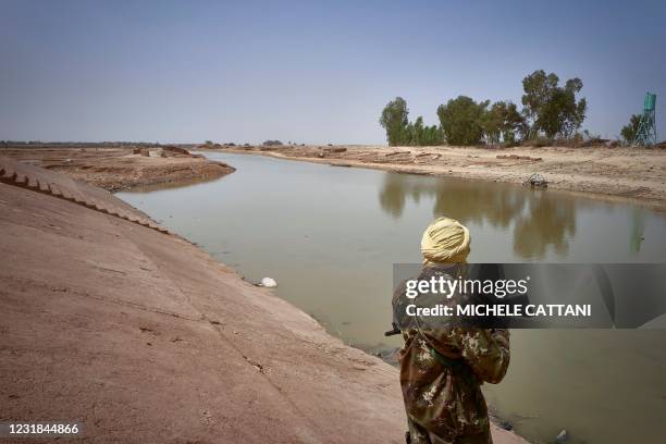 Malian soldier patrols the river bank in Konna on March 20, 2021 as the Malian Prime Minister and his delegation visit the town in central Mali to...