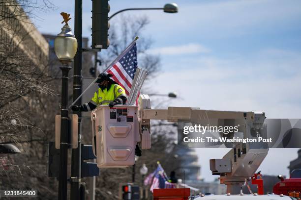 Kionna Twitty and workers with the Mayor Muriel Bowser Administration hang 51-star flags at Black Lives Matter Plaza and along Pennsylvania Avenue on...