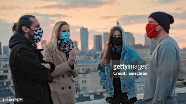 hipster friends meeting on a rooftop. social life during pandemic - small group of people stock pictures, royalty-free photos & images