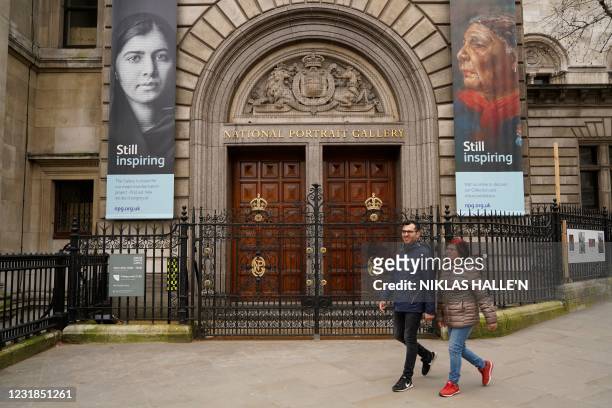 Pedestrians walk past the closed doors at the entrance to the National Portrait Gallery in London on March 21 as the government prepares to gradually...
