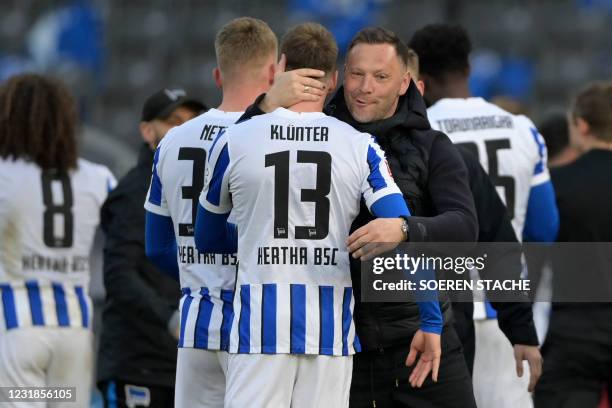 Hertha Berlin's Hungarian head coach Pal Dardai congratulates Hertha Berlin's German defender Lukas Kluenter and other players after the German first...