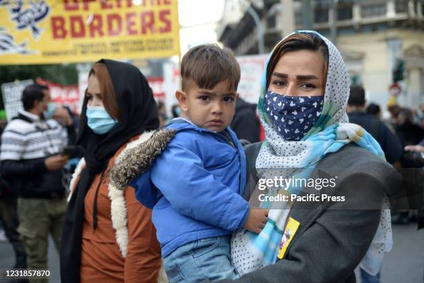 An immigrant woman from Afghanistan seen protesting holding her child. Refugees and irregular immigrants protest march in the central streets of the...