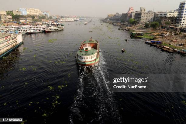 People cross on boat over the pitch black water of the polluted Buriganga River in Dhaka, Bangladesh, on March 21, 2021. Bangladesh has been...