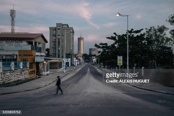 Man crosses a deserted street after voting closed in Poto-Poto, 3rd district of Brazzaville on March 21, 2021. - The Republic of Congo voted on March...