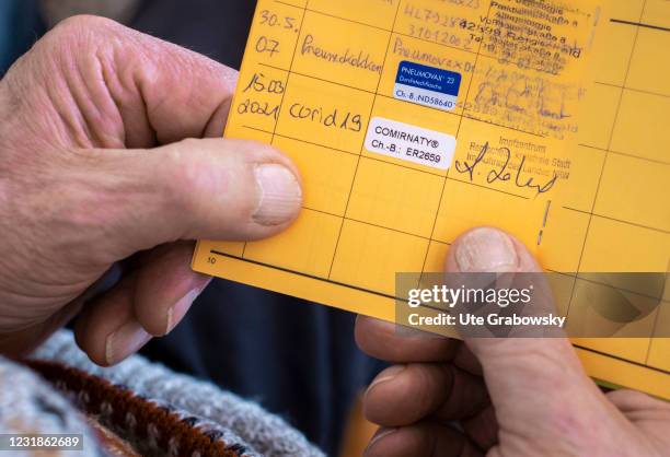 Bonn, Germany In this photo illustration an old man is holding a vaccination certificate with the entry of a Corona vaccination on March 19, 2021 in...