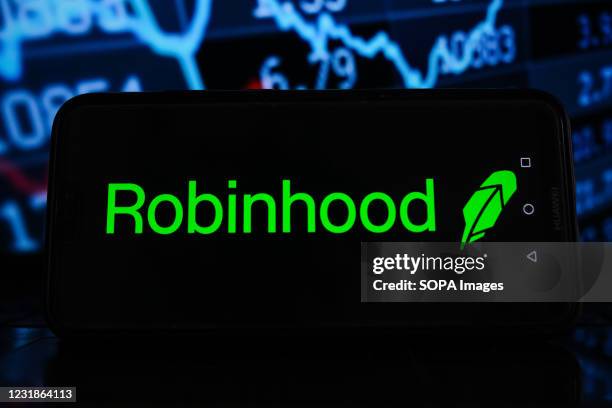 In this photo illustration a Robinhood logo seen displayed on a smartphone with stock market percentages in the background.