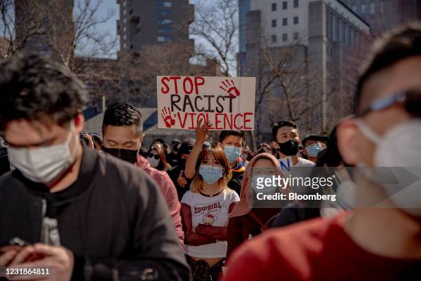 Demonstrators hold signs during an AAPI Rally Against Hate in New York, U.S., on Sunday, March 21, 2021. Stop AAPI Hate, a group that tracks...