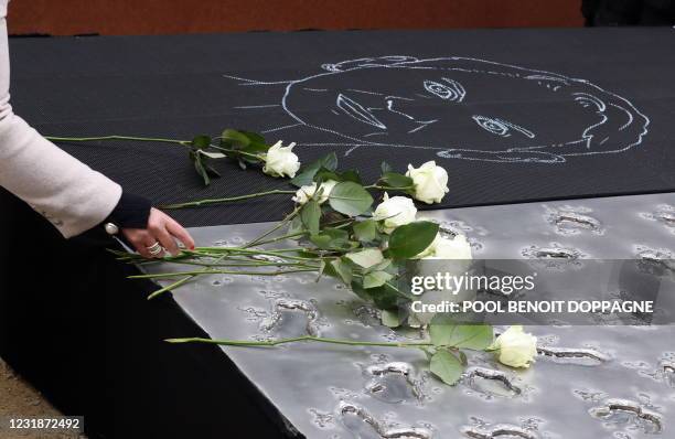 Illustration shows victims and relatives of victims laying down white roses on the monument at a ceremony at the monument to the victims of the 2016...