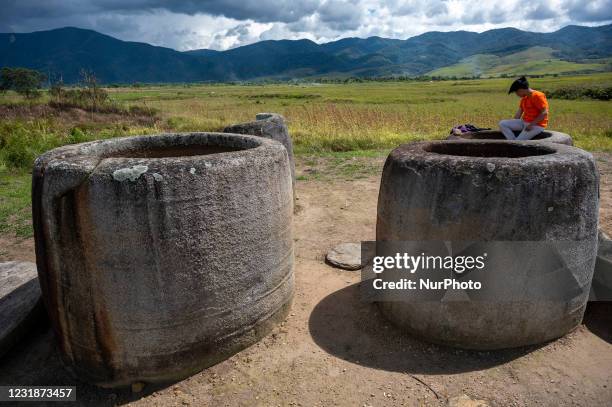 Tourist is on top of a stone vessel while visiting the Pokokea Megalith Site in Hanggira Village, Lore Tengah District, Poso Regency, Central...