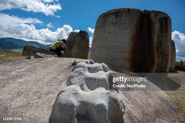 Tourists take pictures while visiting the Pokokea Megalith Site in Hanggira Village, Lore Tengah District, Poso Regency, Central Sulawesi, Indonesia...