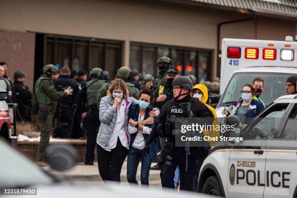 Healthcare workers walk out of a King Sooper's Grocery store after a gunman opened fire on March 22, 2021 in Boulder, Colorado. Dozens of police...