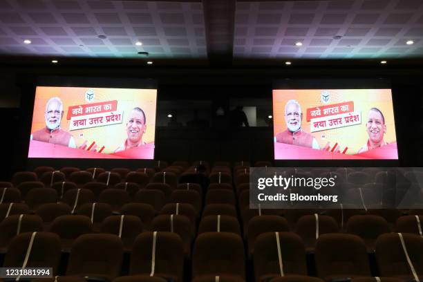 India Prime Miniter Narendra Modi and Uttar Pradesh Chief Minister Yogi Adityanath are displayed on screens ahead of a news conference with...