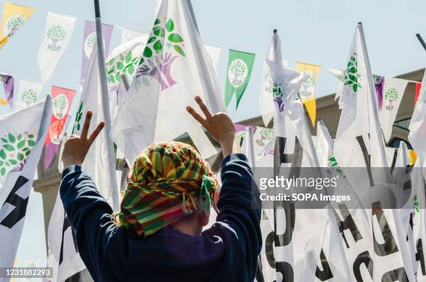 Young Kurdish Peoples' Democratic Party supporter shows signs with her fingers in support of the party during the launch of election campaign in...