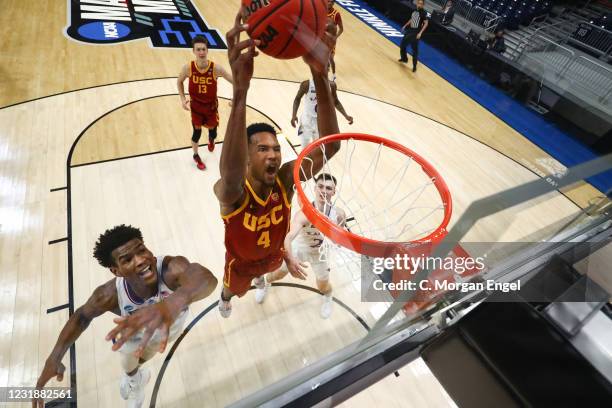 Evan Mobley of the USC Trojans dunks on Ochai Agbaji of the Kansas Jayhawks during the first half in the second round of the 2021 NCAA Division I...