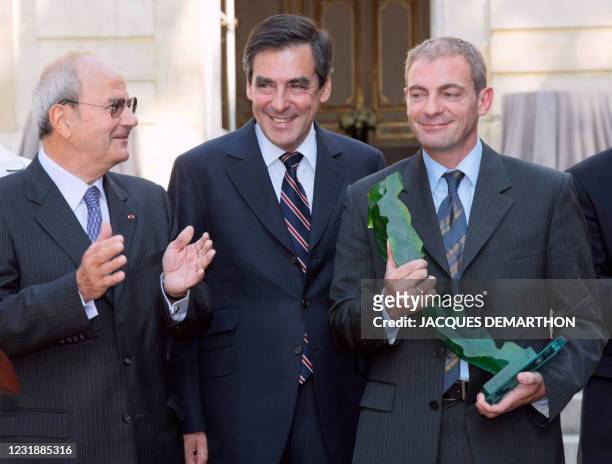 Le lauréat du Prix de l'Audace Créative 2008, Emmanuel Picot , président de la société Evolis, pose aux côtés du Premier ministre François Fillon et...