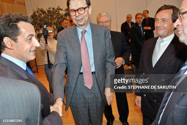 Le ministre de l'Economie et des Finances Nicolas Sarkozy salue le PDG de Renault Louis Schweitzer sous les yeux du directeur général...
