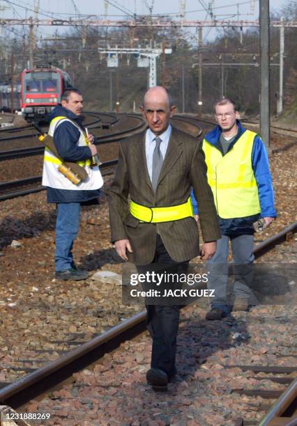 Head of French national railway company SNCF, Louis Gallois , walks along tracks accompanied by technical agents, 03 March 2004 at Etampes station,...