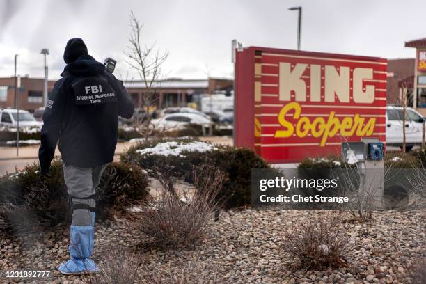 An FBI investigations officer from the evidence response team takes photographs of the crime scene the day after a gunman opened fire at a King...