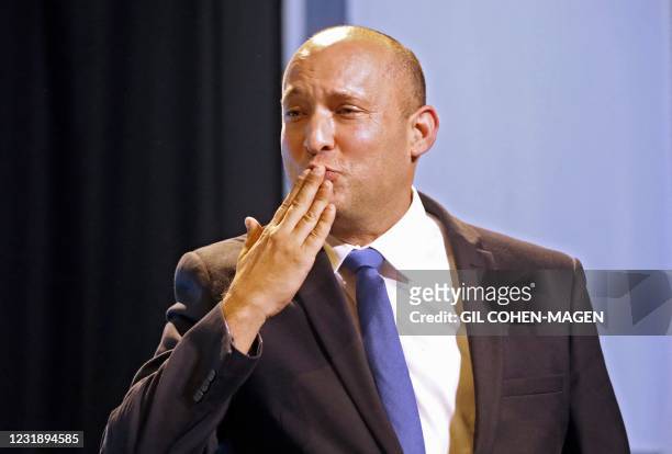 Naftali Bennett, leader of the Israeli right-wing Yamina party, blows kisses as he greets supporters at his party's campaign headquarters in the...