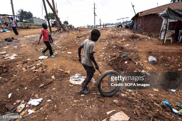 Young boy walks through an empty road construction street site formally filled with housing structures after an eviction that left most local...