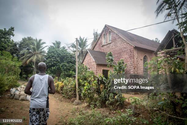 Local guide passes a Zion church on Sierra Leone's Banana Islands. The Banana Islands were once a slave trading port. They are now home to a few...