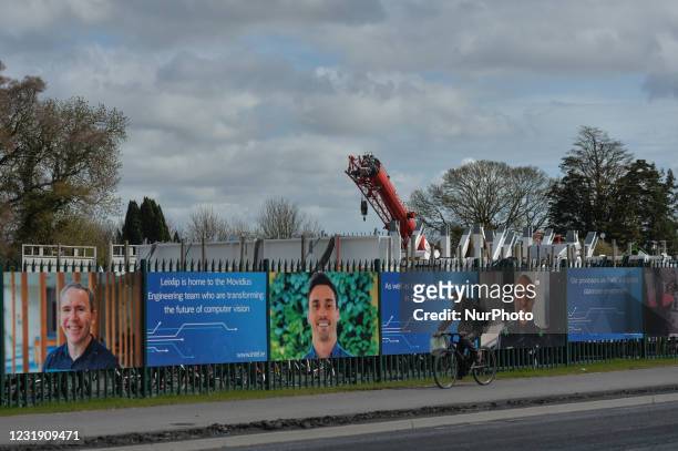 Man cycles by the construction site fence of a new microchip manufacturing facility on Intel's Leixlip campus in Co. Kildare after the company...