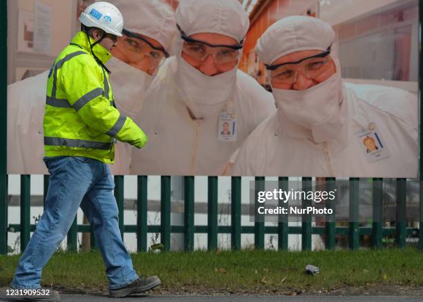 Man walks past the construction site fence of a new microchip manufacturing facility on Intel's Leixlip campus in Co. Kildare after the company...