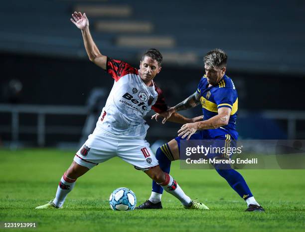 Juan Manuel Olivares of Defensores de Belgrano fights for the ball with Julio Buffarini of Boca Juniors during a match between Boca Juniors and...