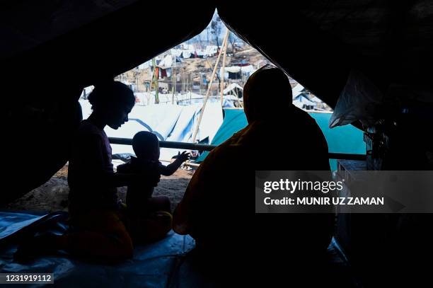 Rohingya refugee family rests in a temporary shelter days after a fire burnt their home at a refugee camp in Ukhia, in the southeastern Cox's Bazar...