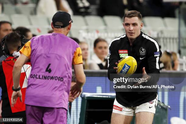 Trey Ruscoe of the Magpies is seen warming up as the medical sub during the 2021 AFL Round 02 match between the Carlton Blues and the Collingwood...